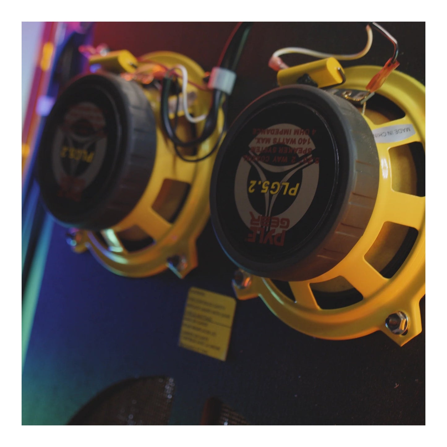 Yellow speakers with visible branding on a dark background