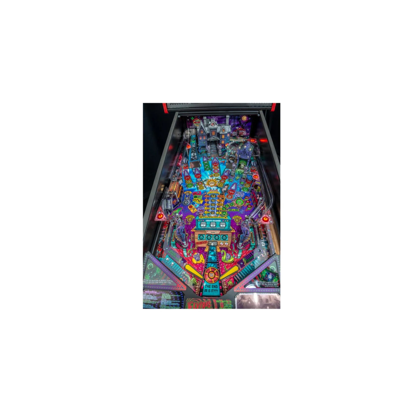 A close-up of the Elvira's House of Horrors playfield, highlighting the "Deadhead Family Crypt" and "Junk in the Trunk" toys.