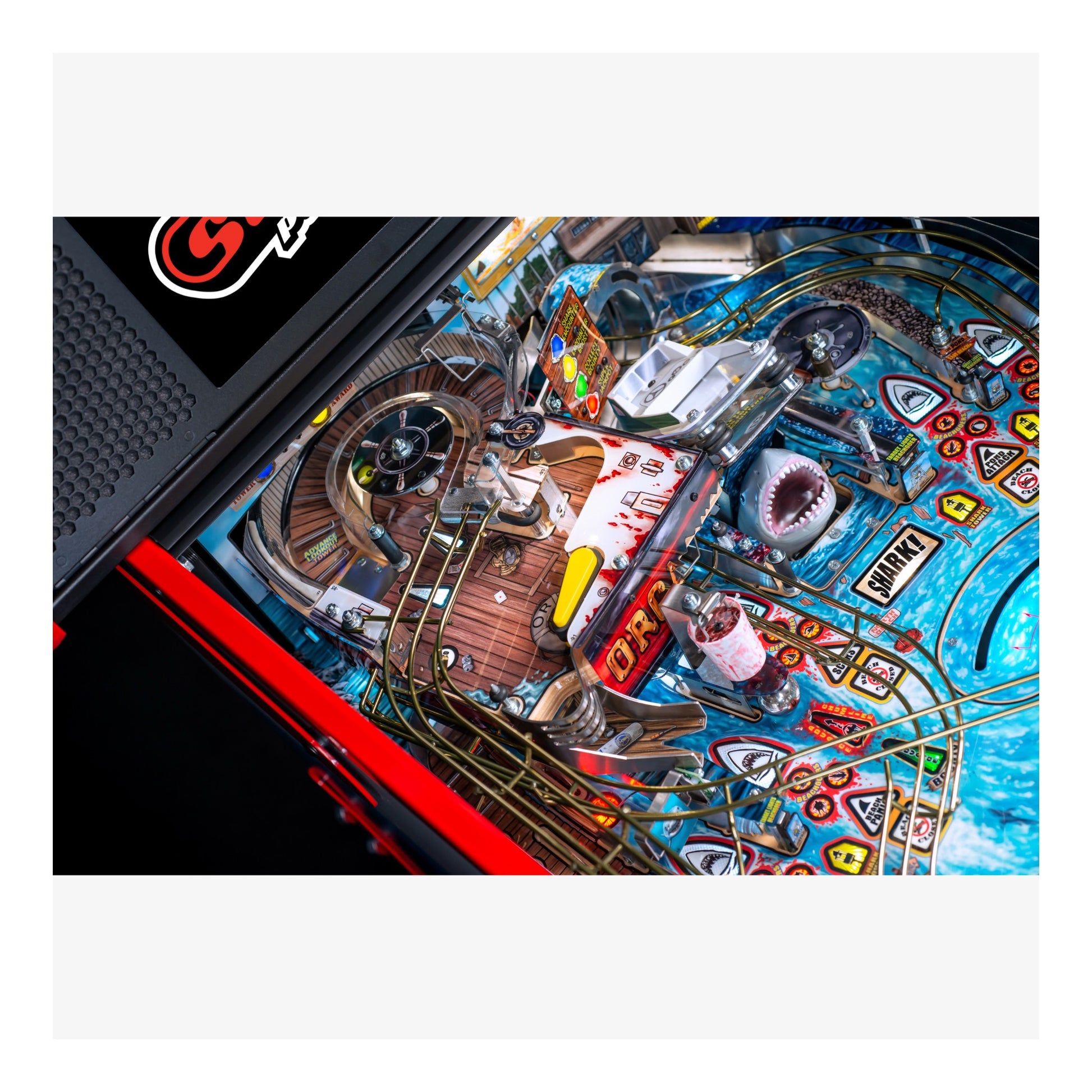 Close-up of a pinball machine with colorful design and various components.