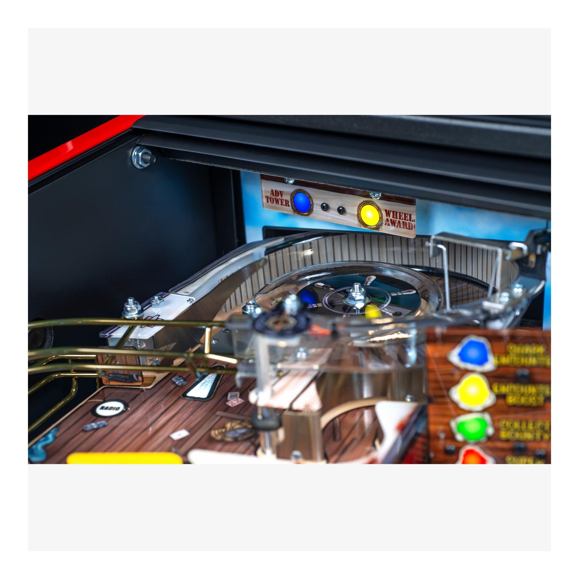 Close-up of a pinball machine with colorful buttons and wooden surface.