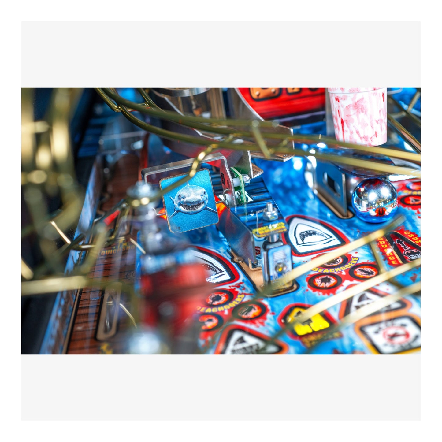 Close-up of a pinball machine with colorful design and various components.