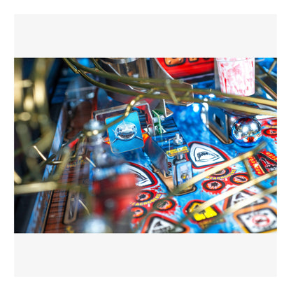 Close-up of a pinball machine with colorful design and various components.