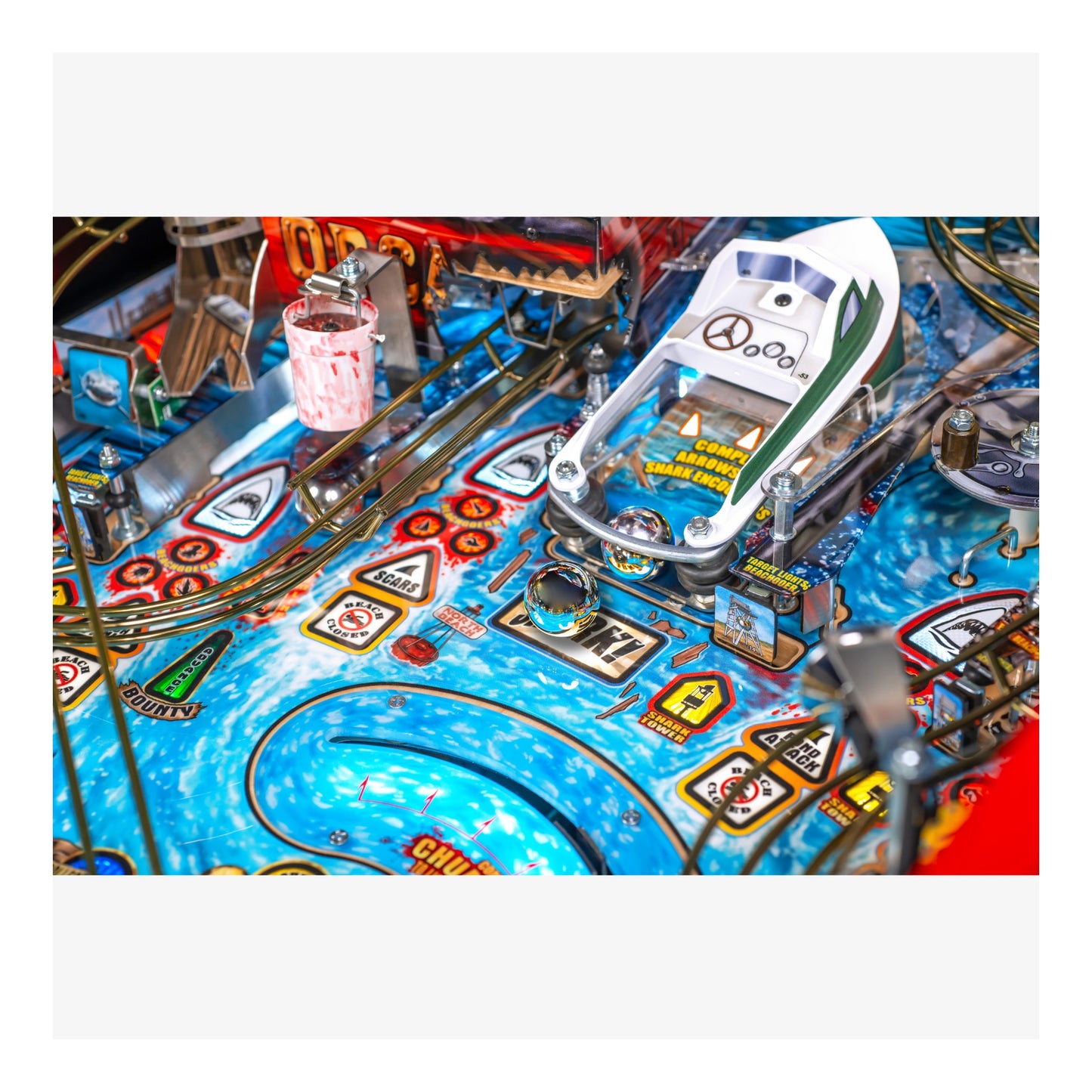 Close-up of a pinball machine with colorful playfield and various components.