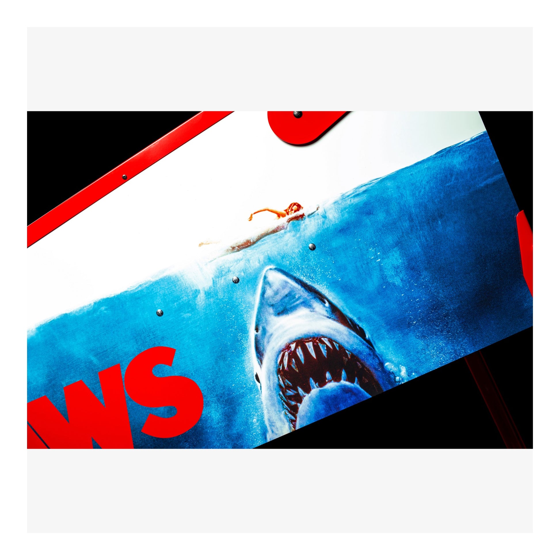 Surreal image of a shark attacking a woman on a beach with 'WS' text overlay.