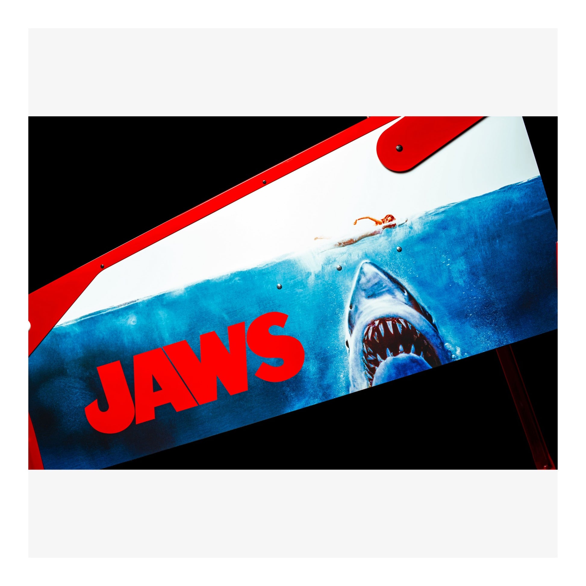 Movie poster for 'Jaws' with a shark and surfboard design.