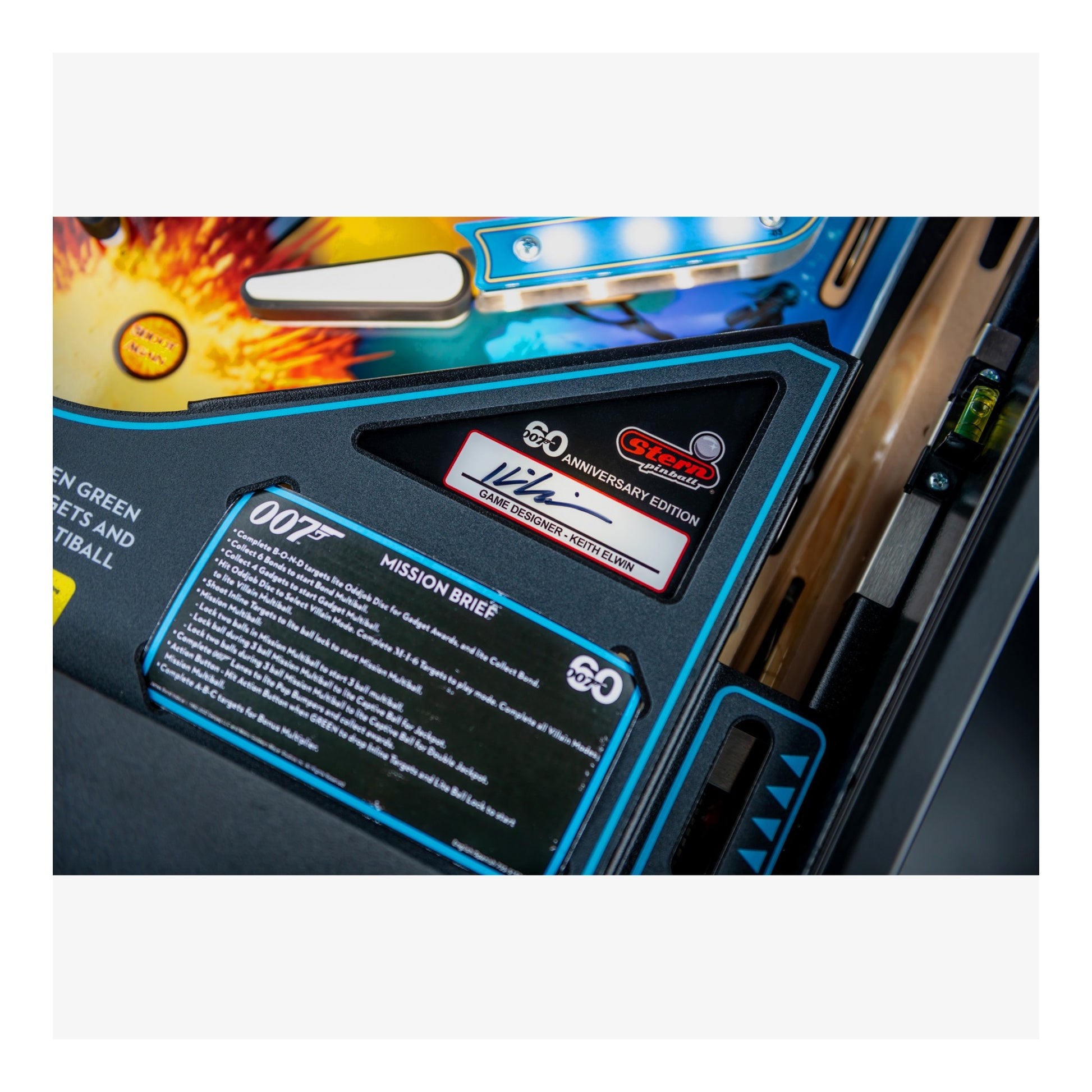 Close-up of a pinball machine with branding and text on a white background