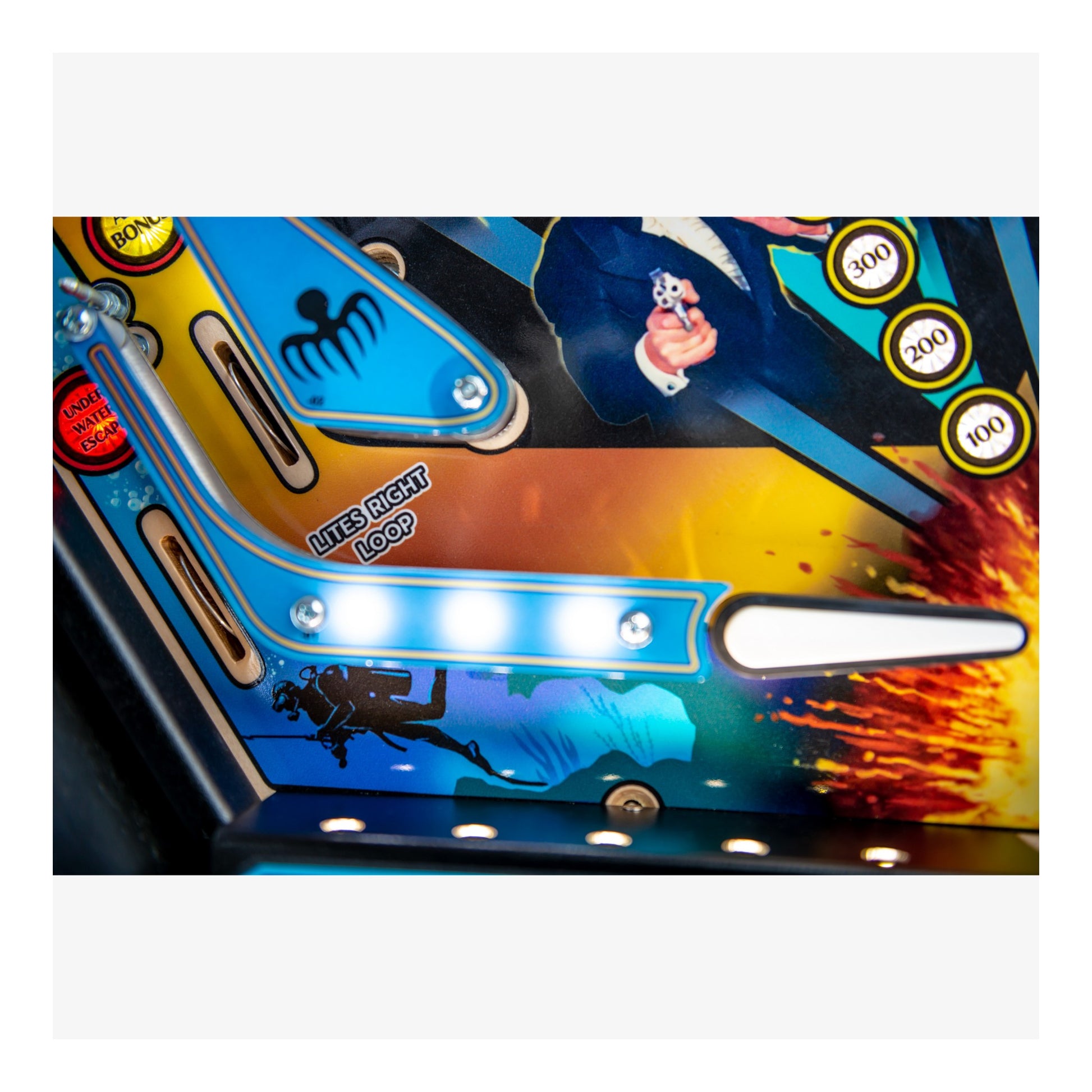 Close-up of a colorful pinball machine with vibrant graphics and bright lights.