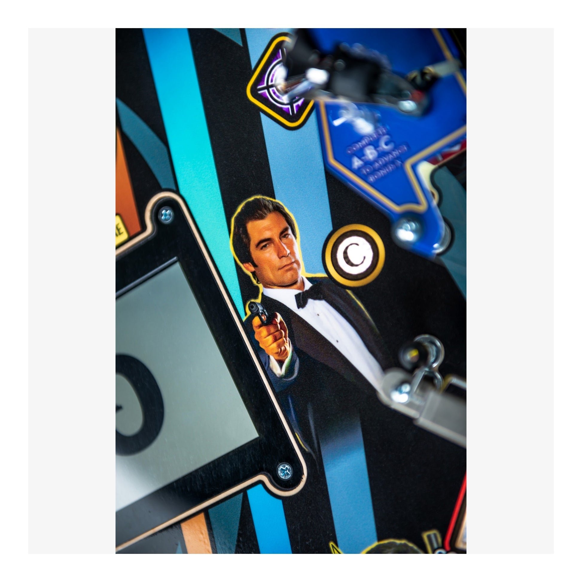 Pinball machine with a character in a tuxedo holding a gun, set against a colorful background.