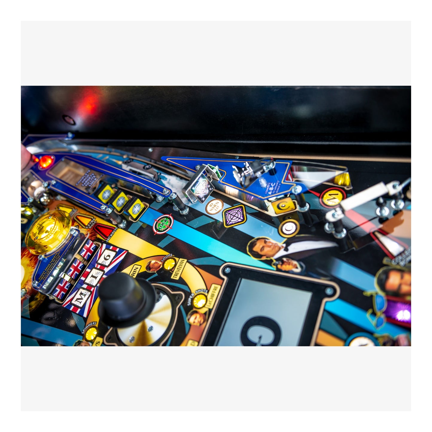 Close-up of a colorful pinball machine with various components and lights.