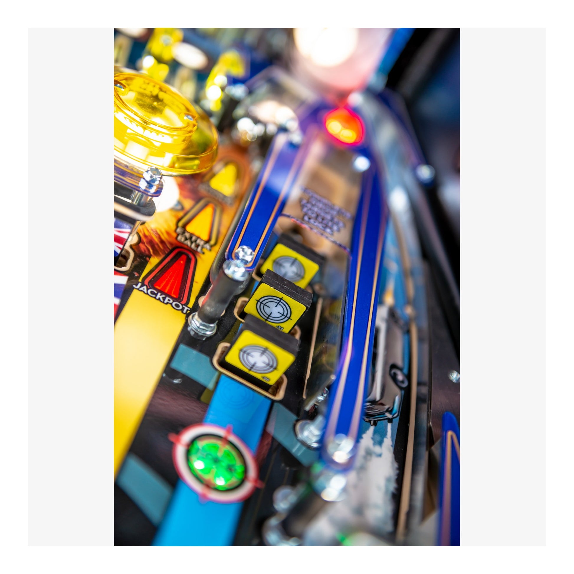 Close-up of a colorful pinball machine with various components.