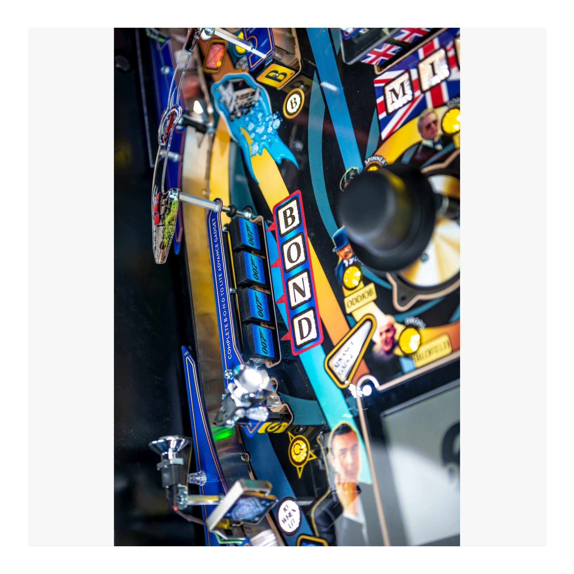 Close-up of a pinball machine with 'Bond' branding and colorful design elements.
