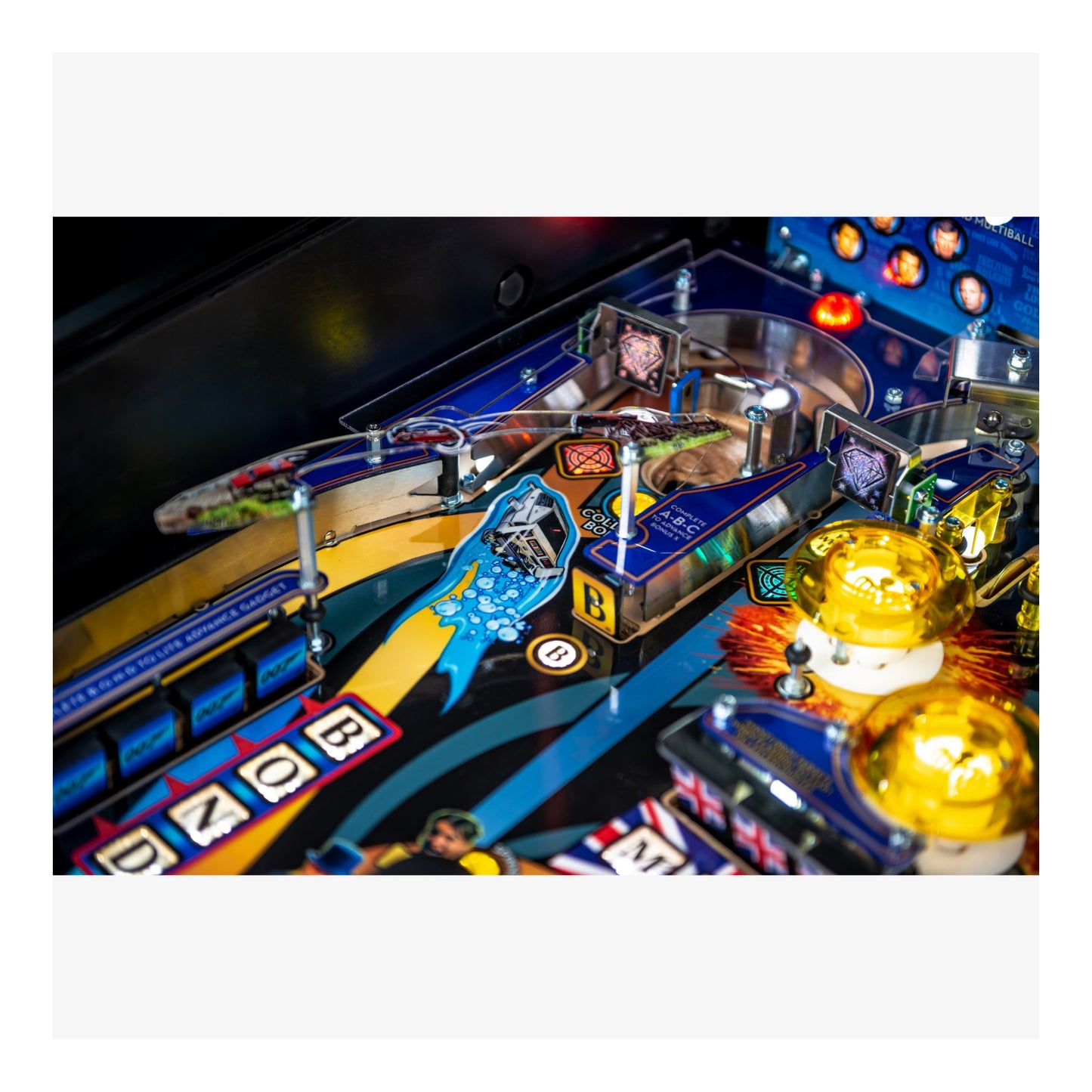 Close-up of a pinball machine with colorful playfield and various components.