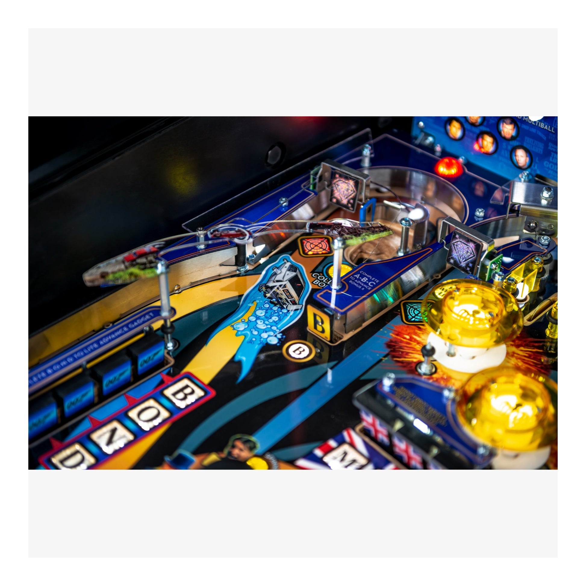 Close-up of a pinball machine with colorful playfield and various components.