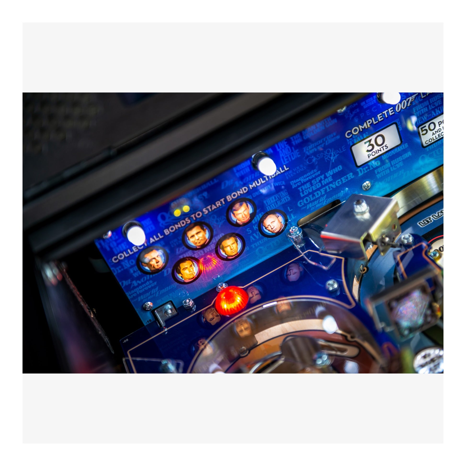 Close-up of a pinball machine's playfield with colorful lights and buttons.