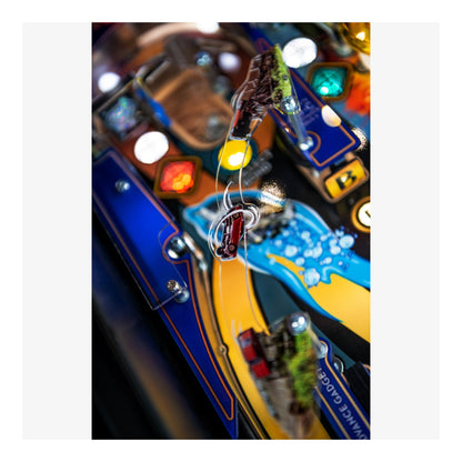 Close-up of a colorful pinball machine with various lights and components.