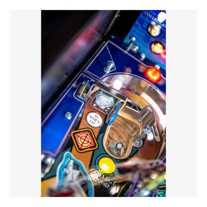 Close-up of a pinball machine's playfield with various components and lights.