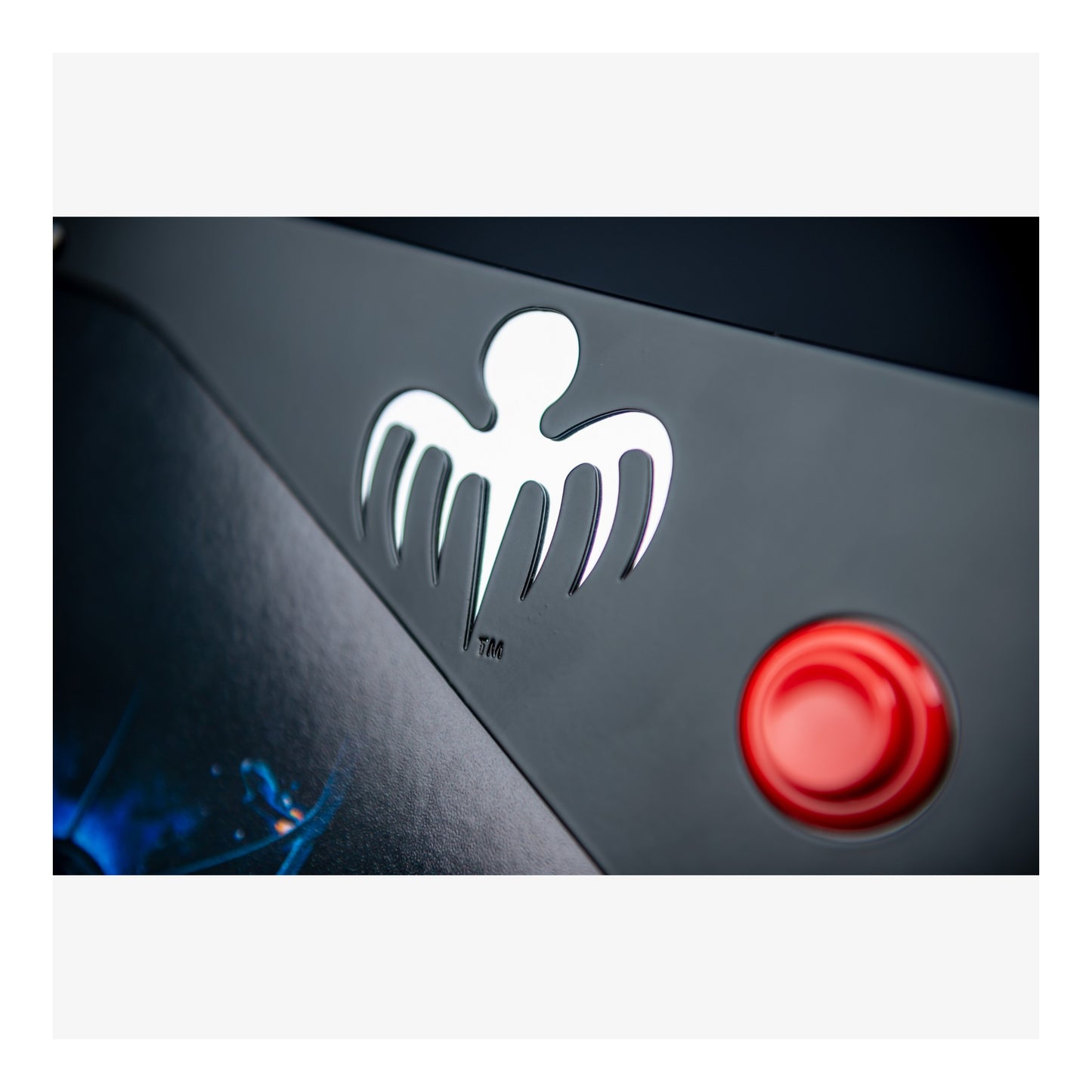 Logo and red button on a black surface