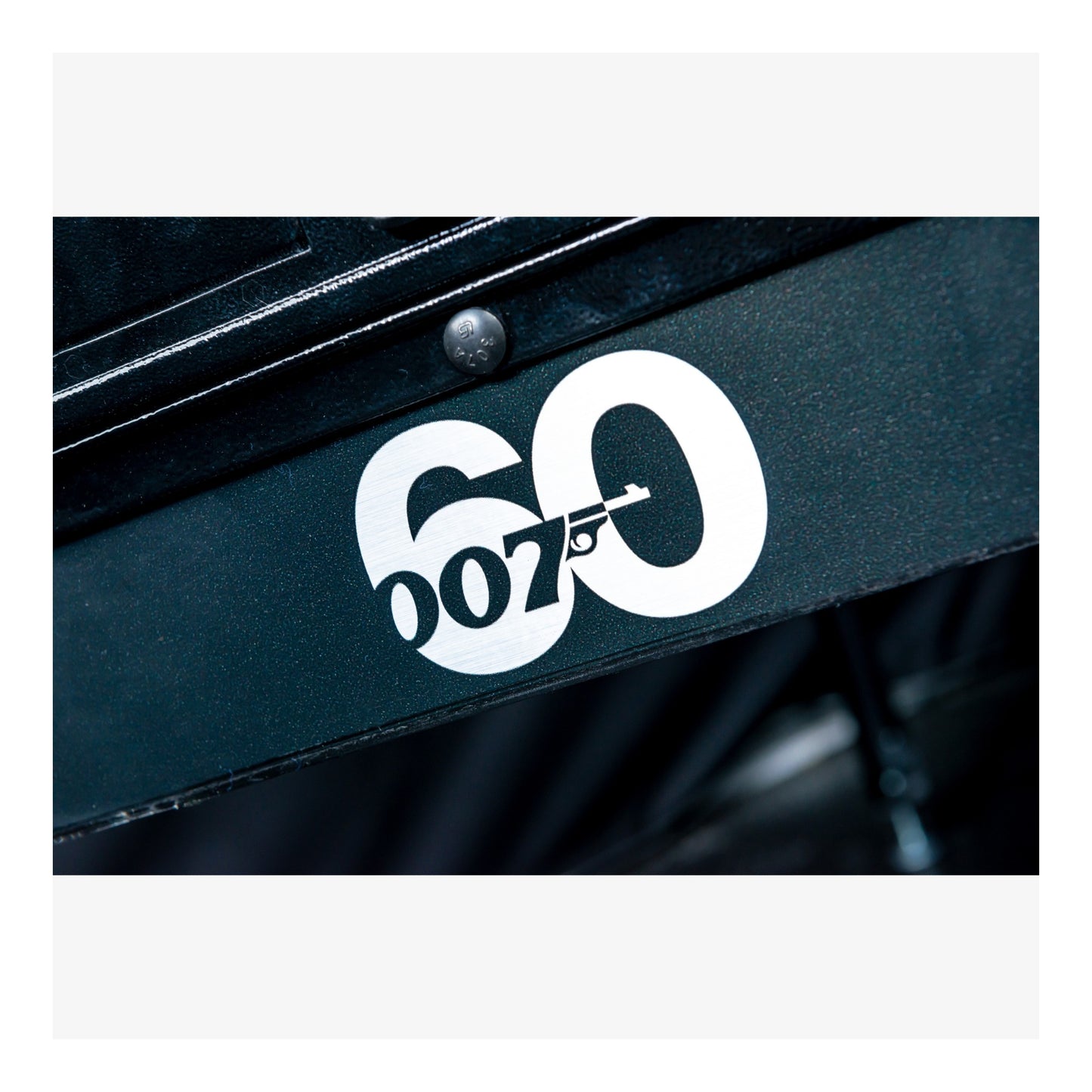 Close-up of a black surface with a white '007' logo on a white background