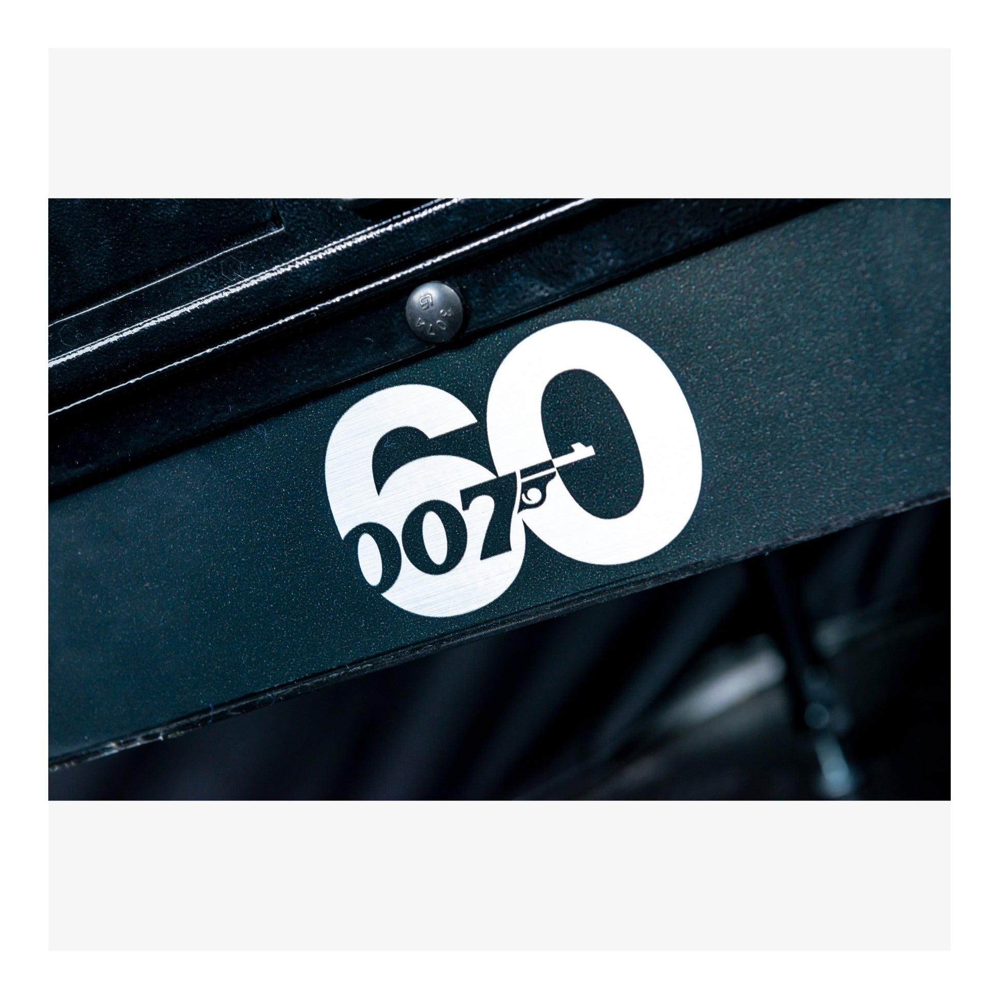 Close-up of a black surface with a white '007' logo on a white background