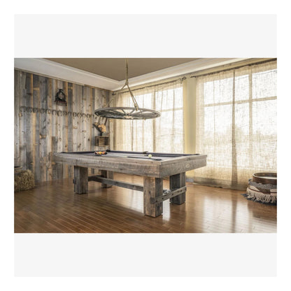 The Canada Billiard Barn pool table with an antique grey stain, shown in a rustic-style game room with a wood wall.