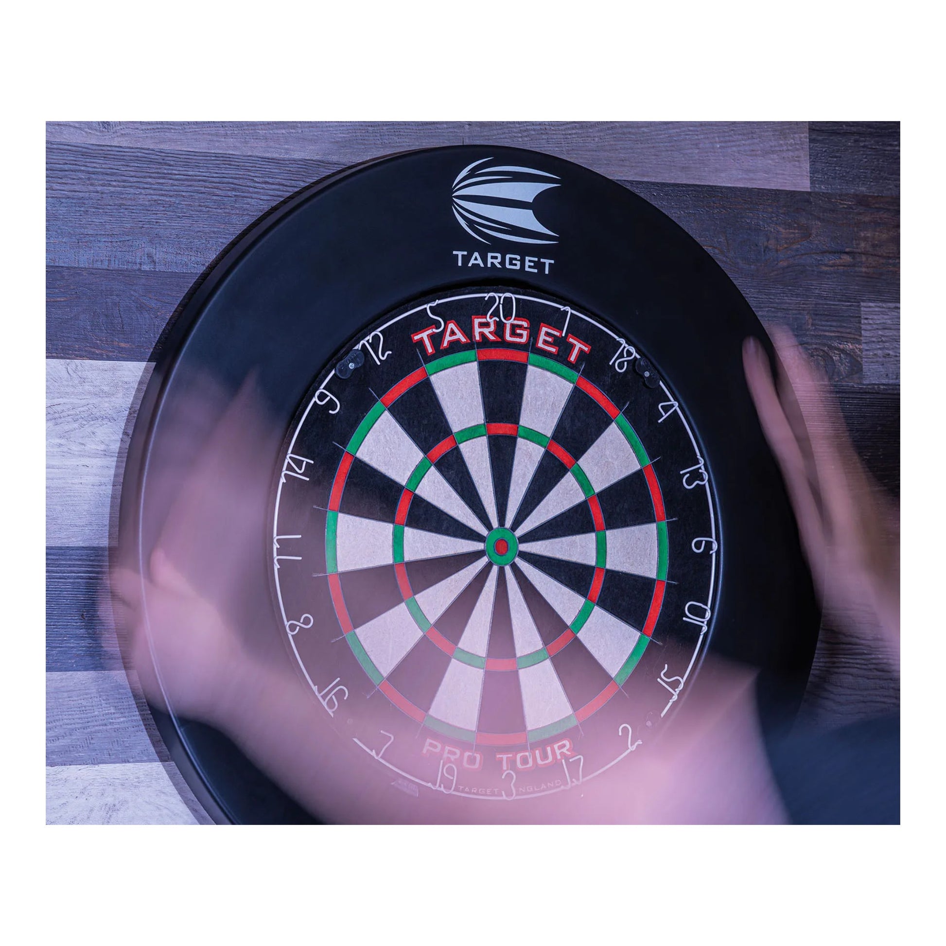 Dartboard with 'Target' branding on a wooden surface surrounded with black Pro Tour