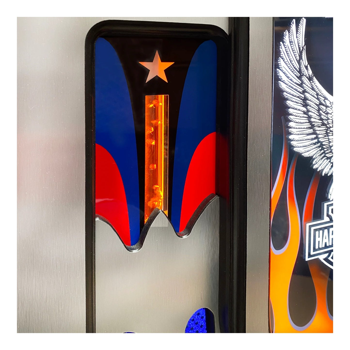 Close-up of a motorcycle with colorful design elements including a star, wings, and flames.