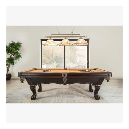 Wooden pool table with cues and balls in a room with large windows and decorative lamps.
