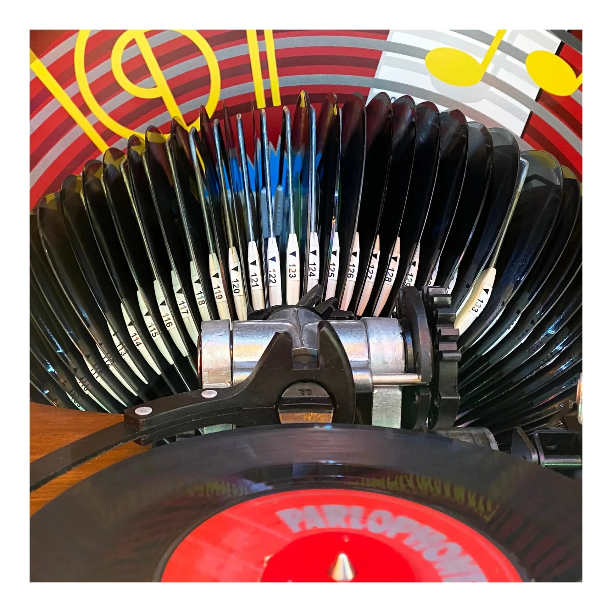 Close-up of a vinyl record player with a colorful background