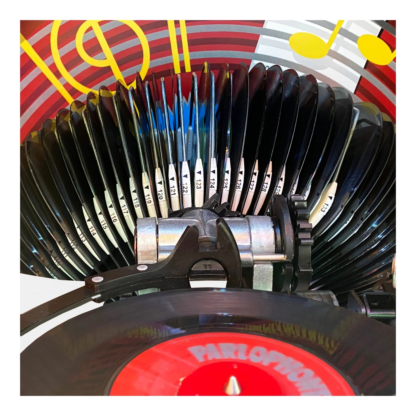 Close-up of a vinyl record player with a colorful background