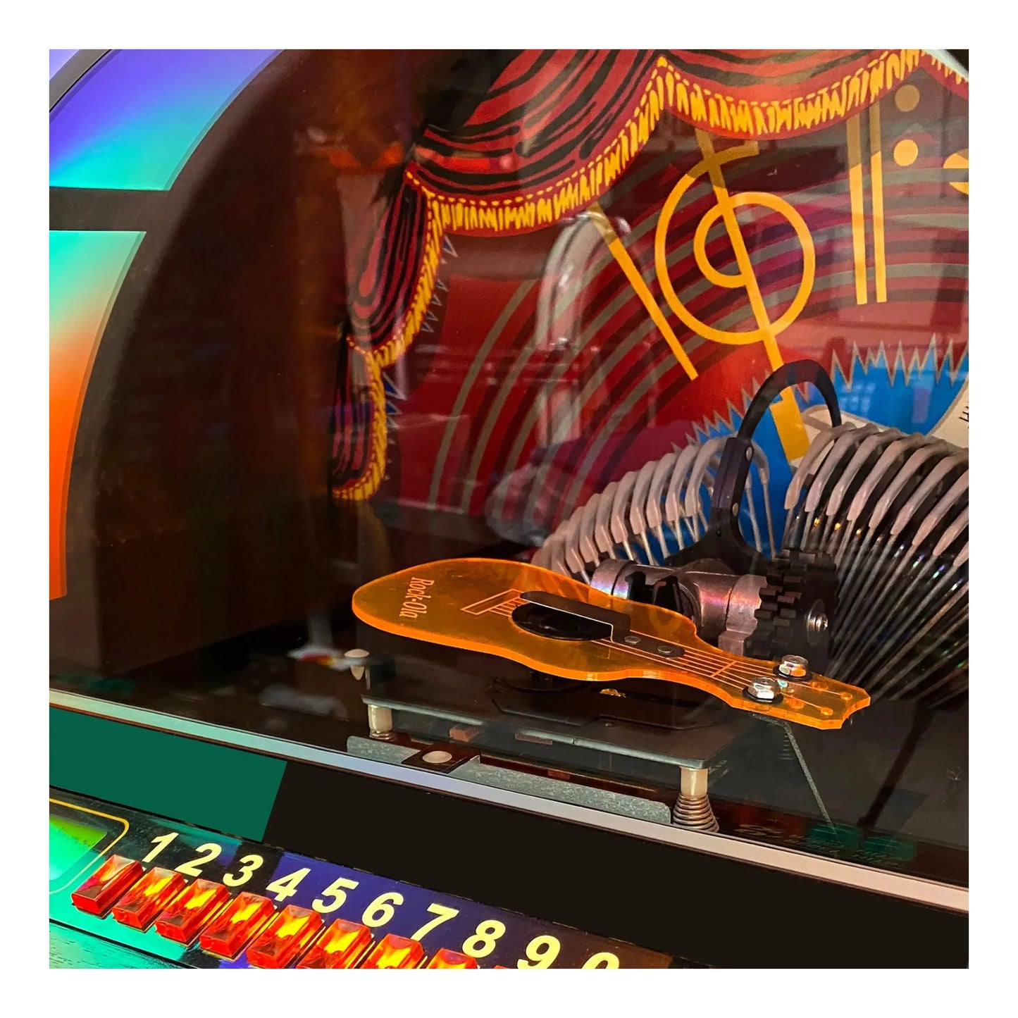 Close-up of a colorful mechanical object with a focus on a guitar-shaped component.
