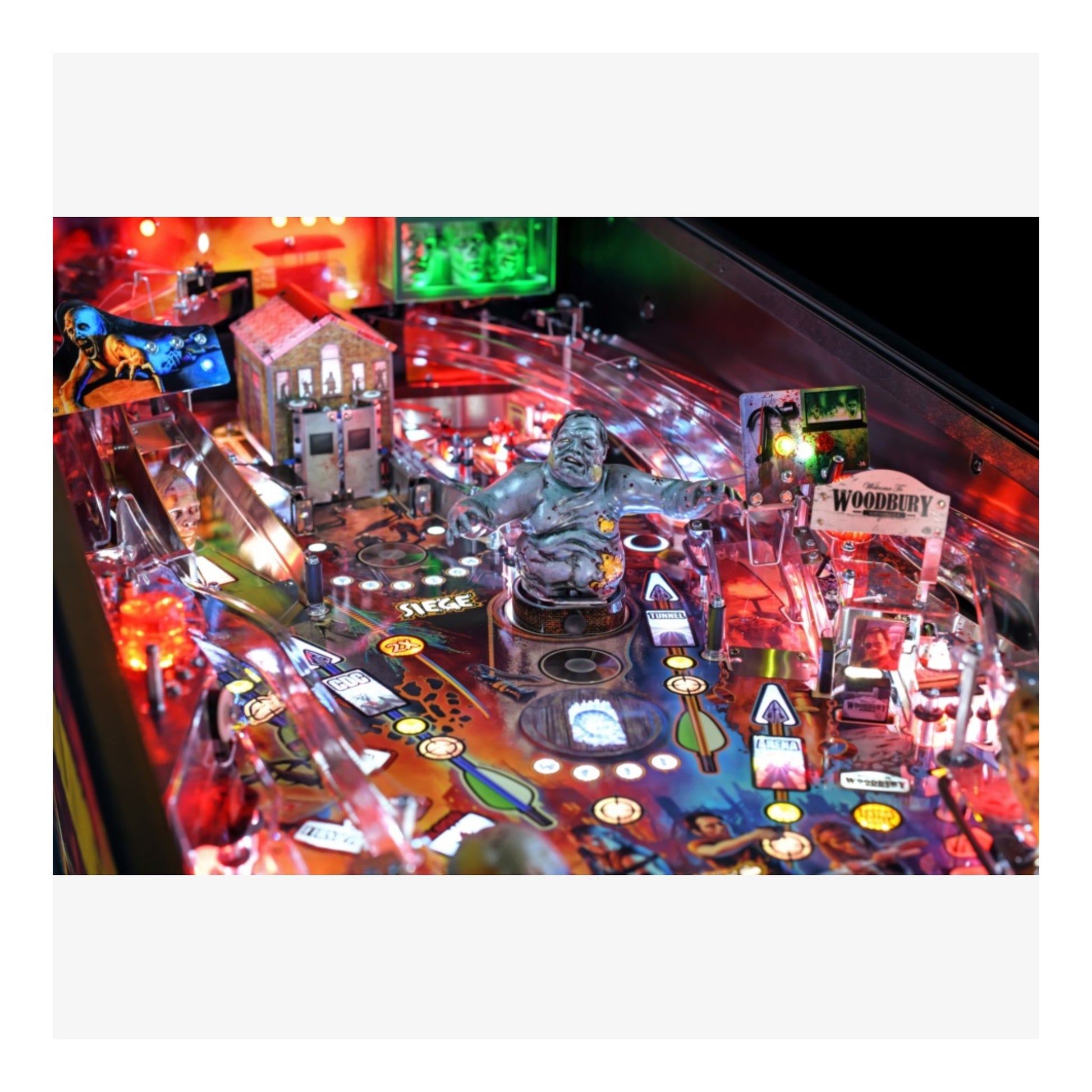 Premium Stern Pinball The Walking Dead.  Pinball machine with colorful lights and various game components on a white background