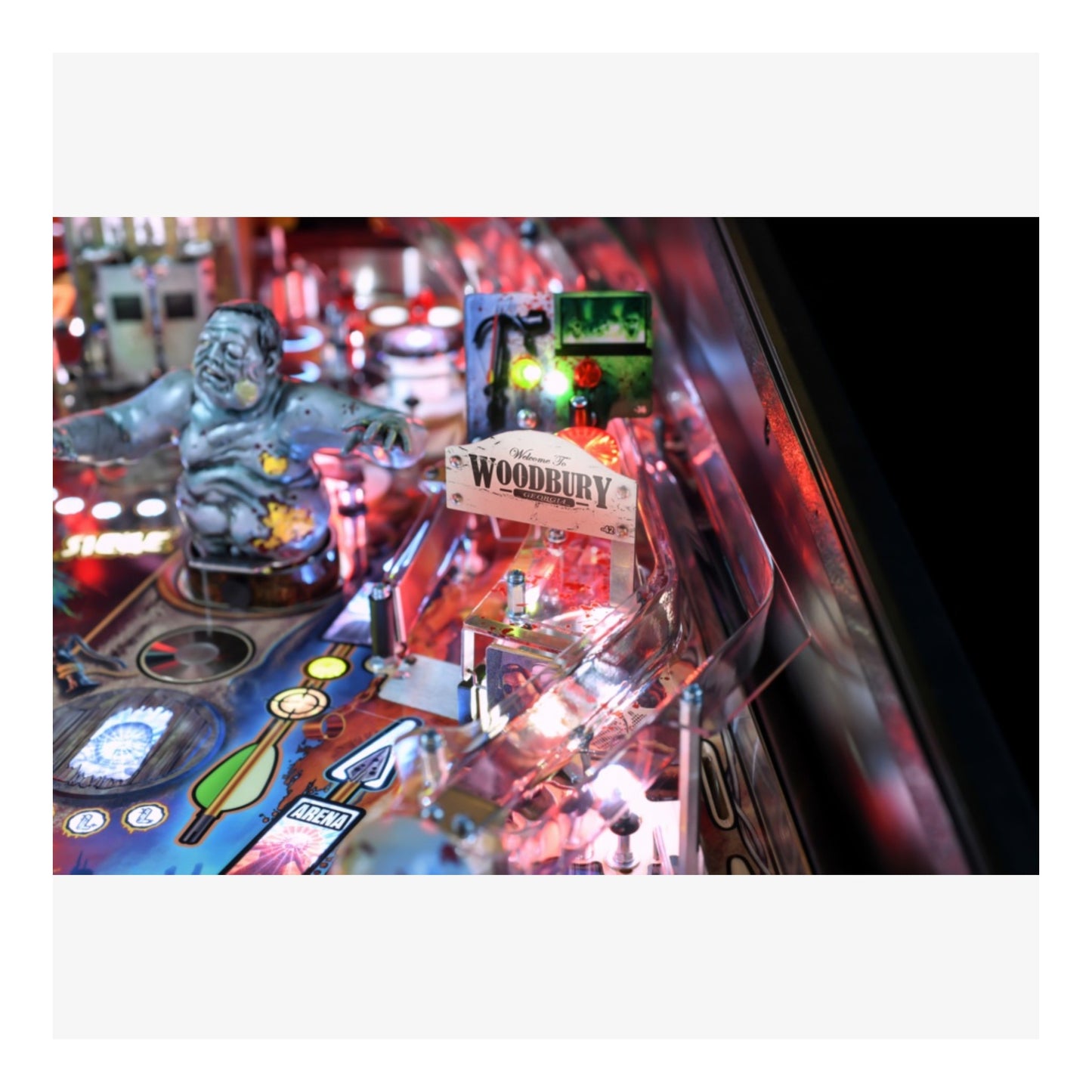 Premium Stern Pinball The Walking Dead.  Close-up of a pinball machine with a 'Woodbury' sign and various game components.