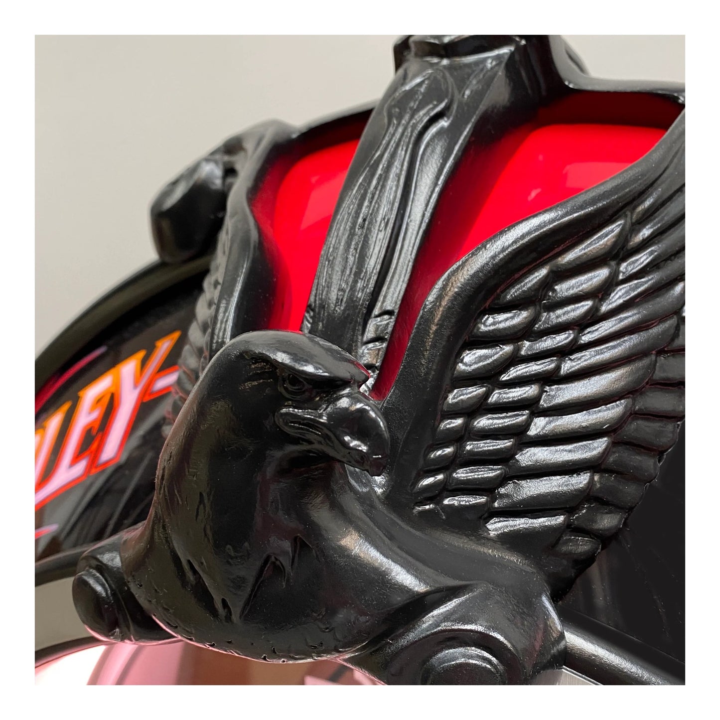 Close-up of a motorcycle with an eagle emblem on a red background