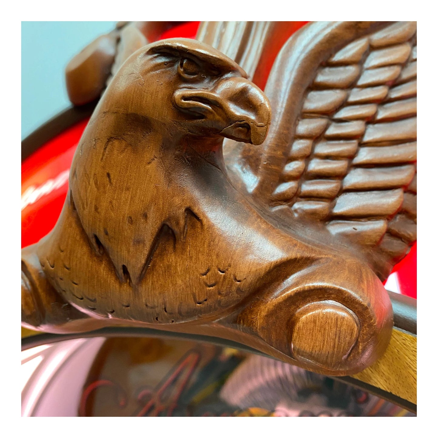 Wooden eagle emblem on a vehicle, with a blurred background