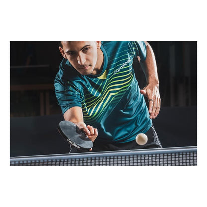 A man playing table tennis, wearing a teal and yellow striped athletic jersey holding a paddle with the Cornilleau logo, with a white table tennis ball in motion.