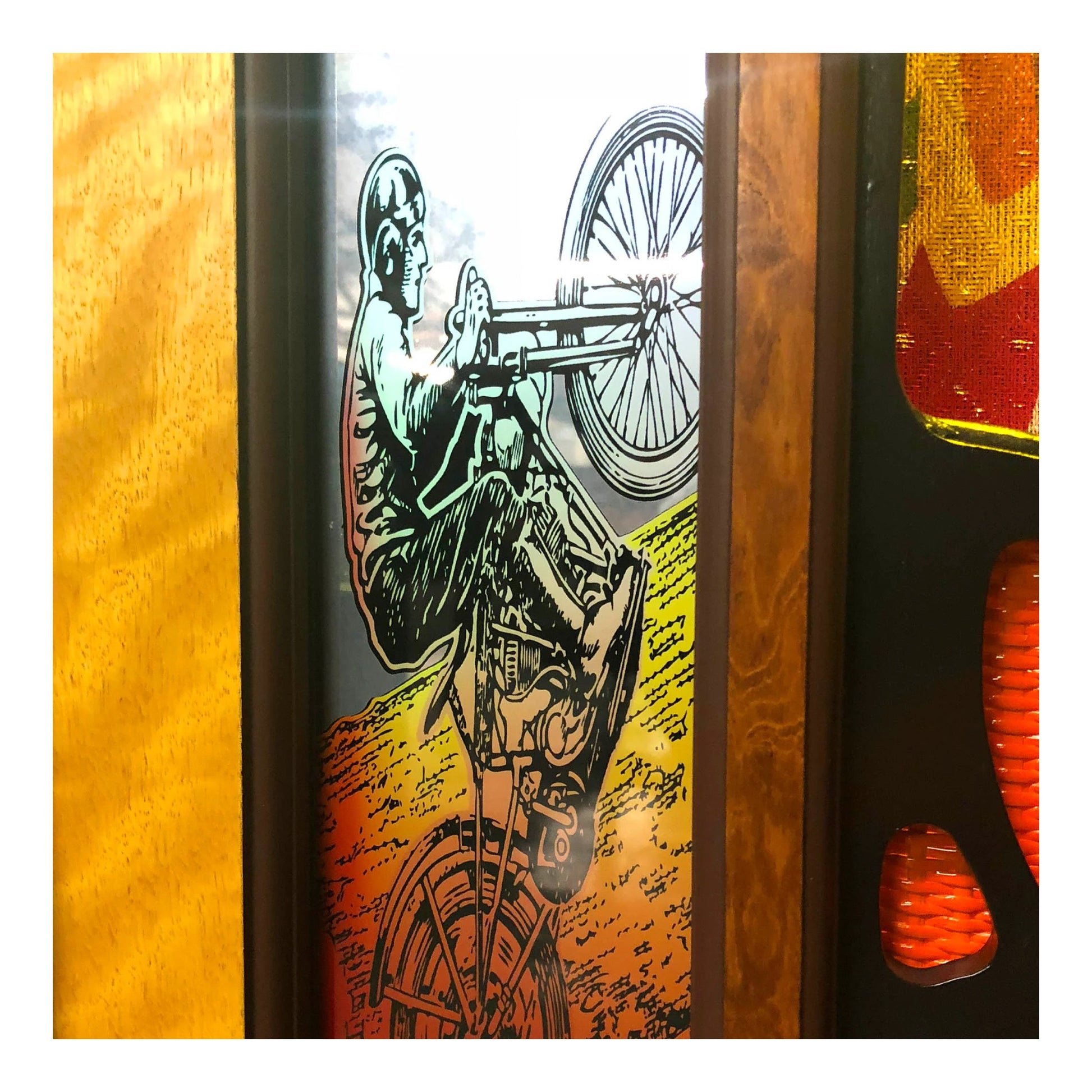 Decorative panel with a skeleton on a motorcycle design against a colorful background