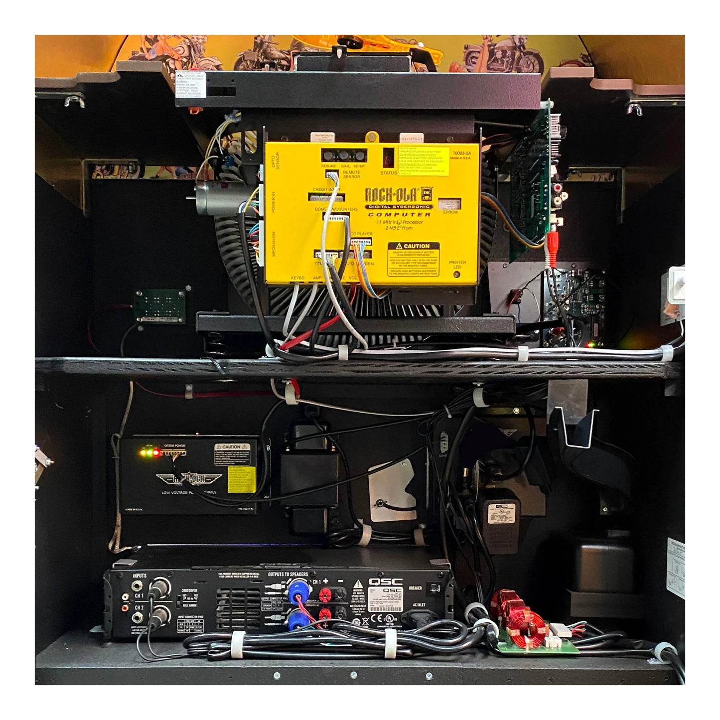 Electrical components including a yellow battery and black equipment in a technical setup.