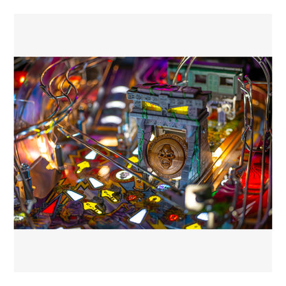 Close-up of a pinball machine with colorful lights and mechanical components.