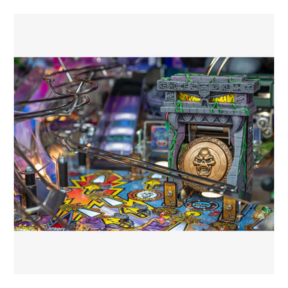 Close-up of a pinball machine with colorful design and metallic elements.