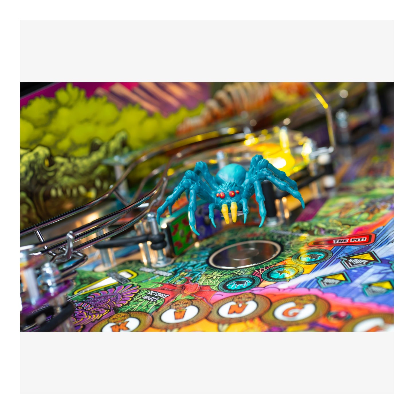 Colorful pinball machine with a detailed playfield and a blue spider figure.