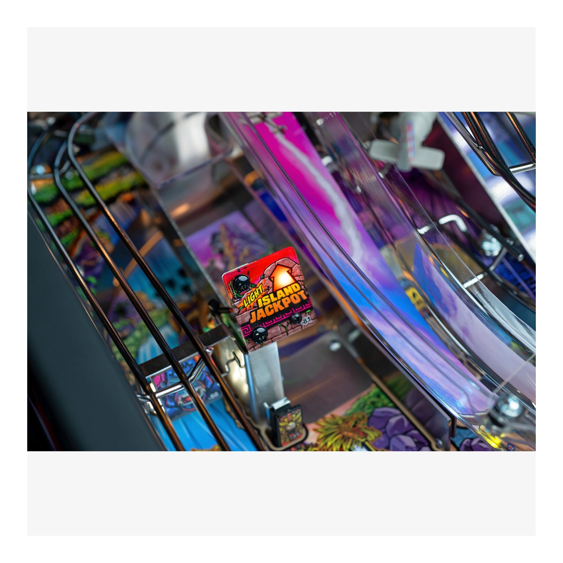 Close-up of a colorful pinball machine with a 'Hot Land Jackpot' ticket.