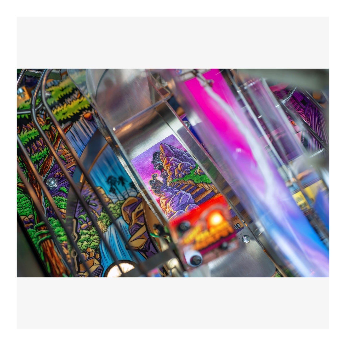 Close-up of a colorful pinball machine with vibrant graphics and bright lights.