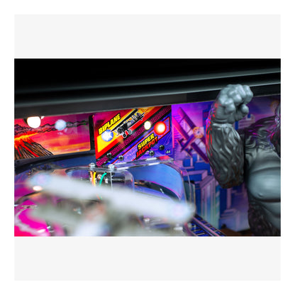Pinball machine with colorful lights and a large fist figure on a white background