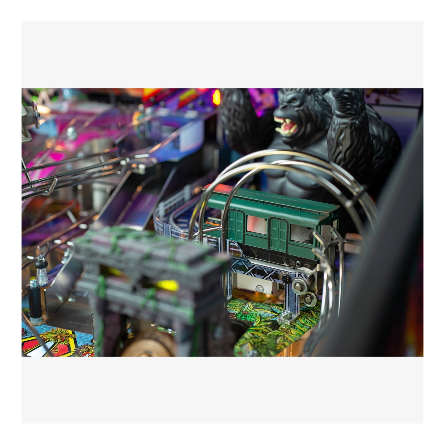 Close-up of a pinball machine with detailed playfield and figures.