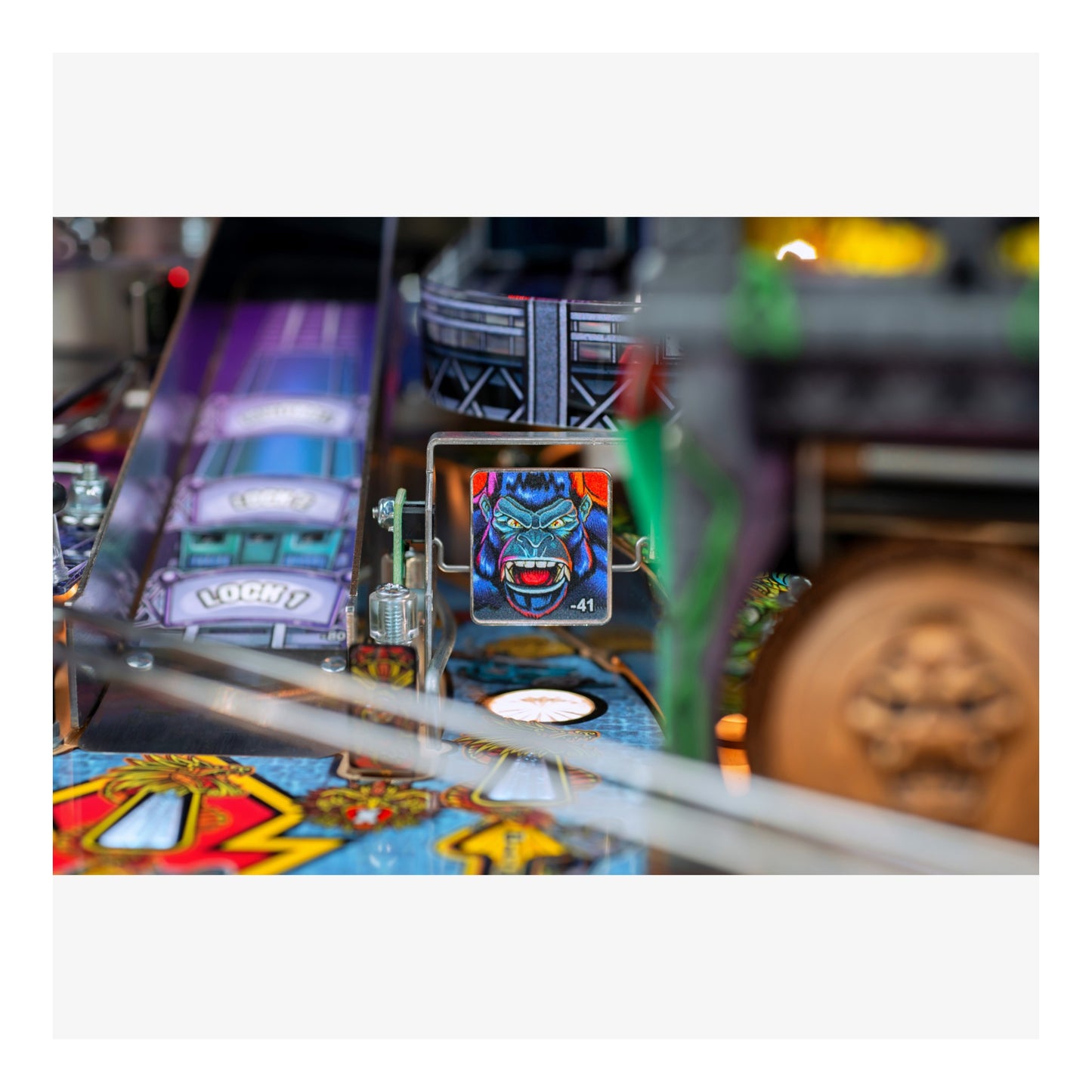 Close-up of a pinball machine with a character figure and colorful design.
