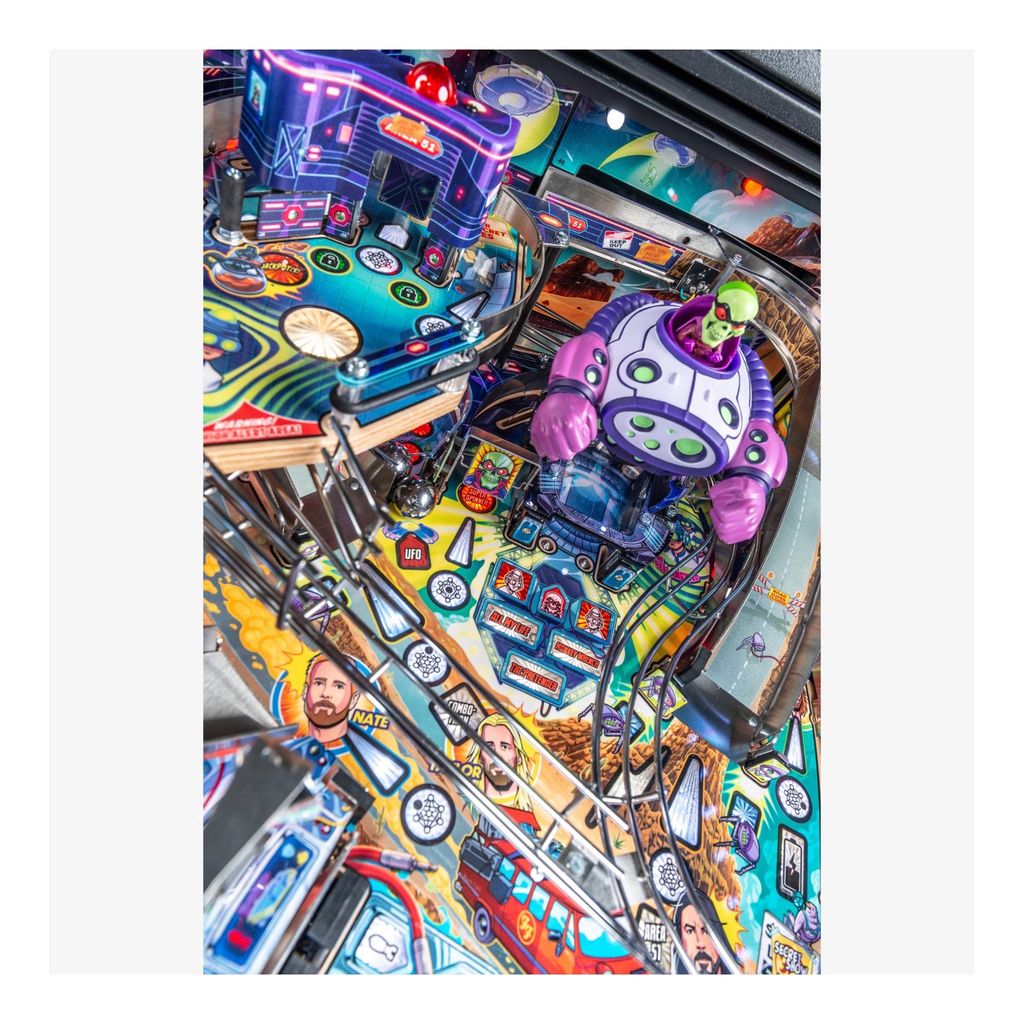 Close-up of a colorful pinball machine with vibrant graphics and a robot figure.