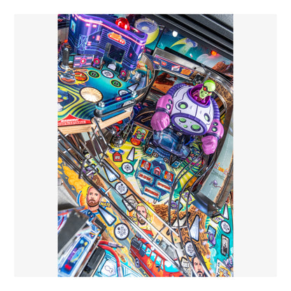 Close-up of a colorful pinball machine with vibrant graphics and a robot figure.
