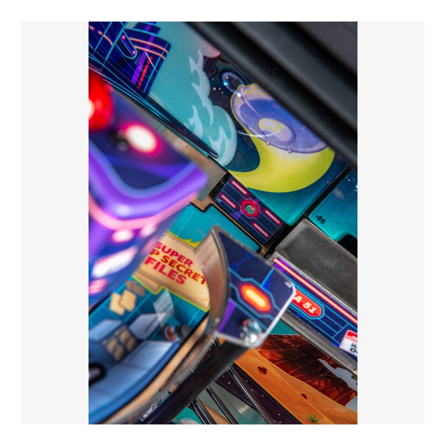 Close-up of a colorful pinball machine with various lights and text.