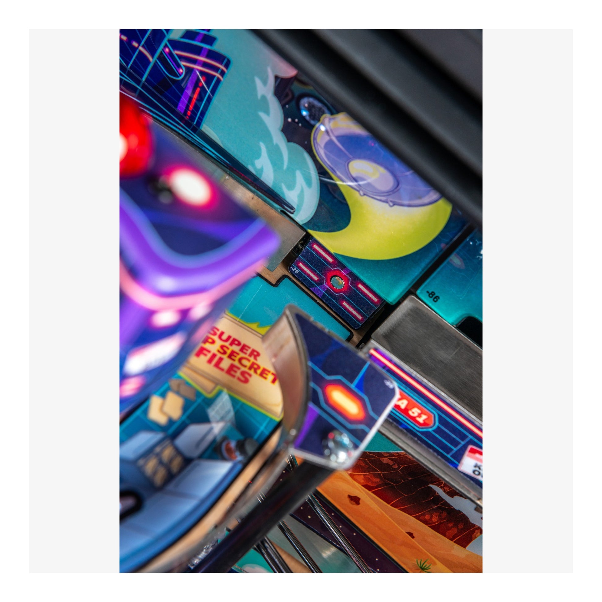 Close-up of a colorful pinball machine with various lights and text.