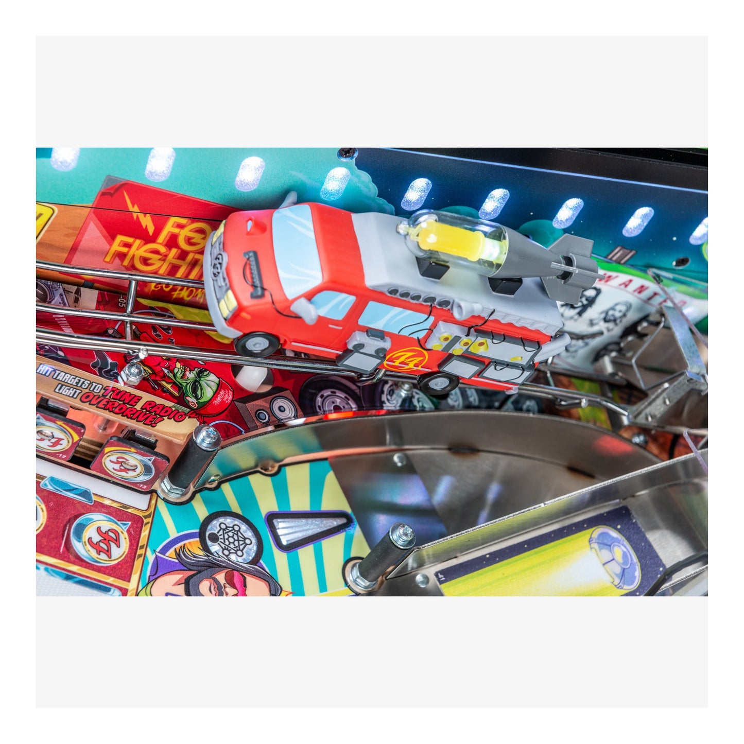 Close-up of a pinball machine with a fire truck and airplane design.